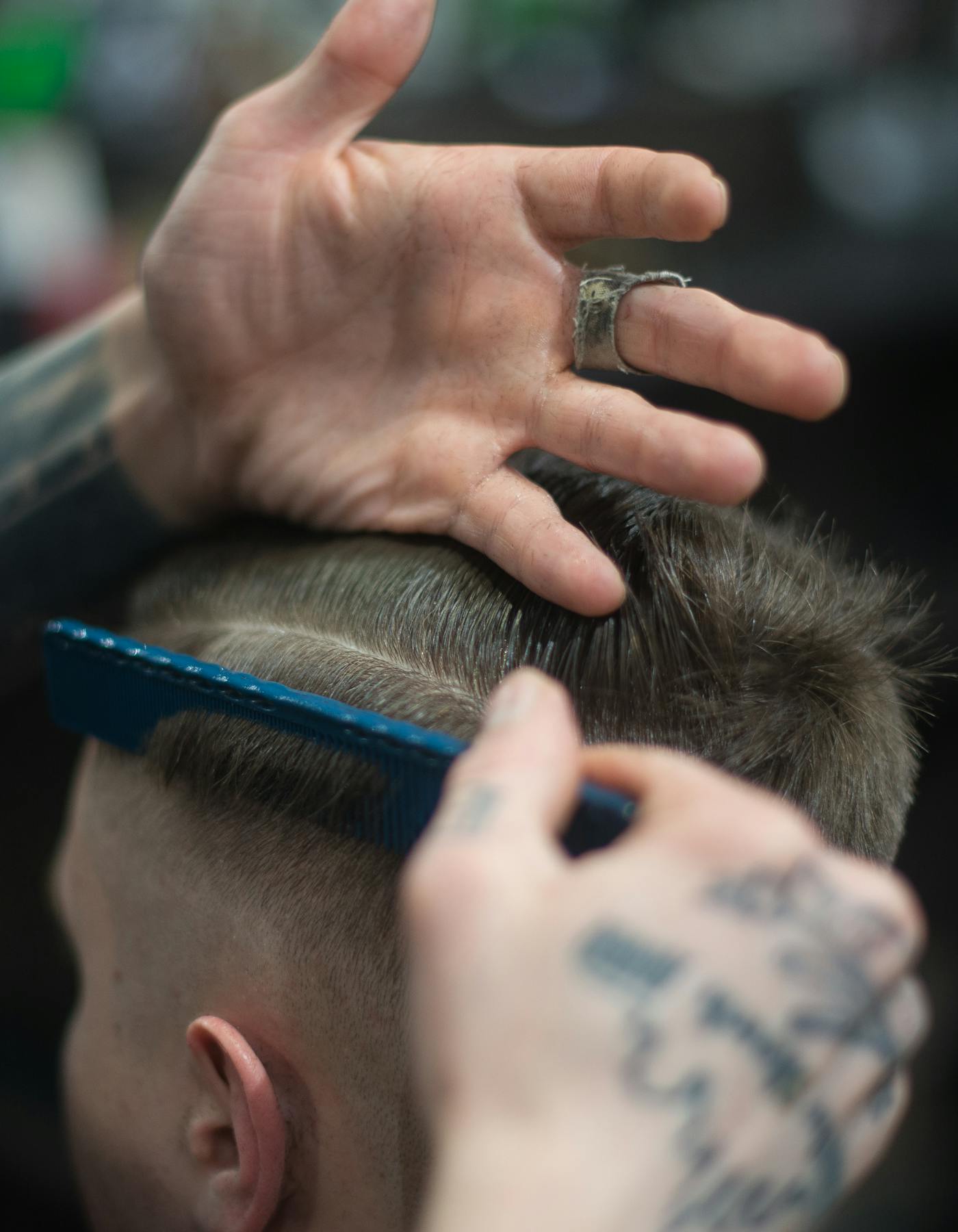 Interior de barbearia moderna com cadeiras, espelhos e atendimento em curso