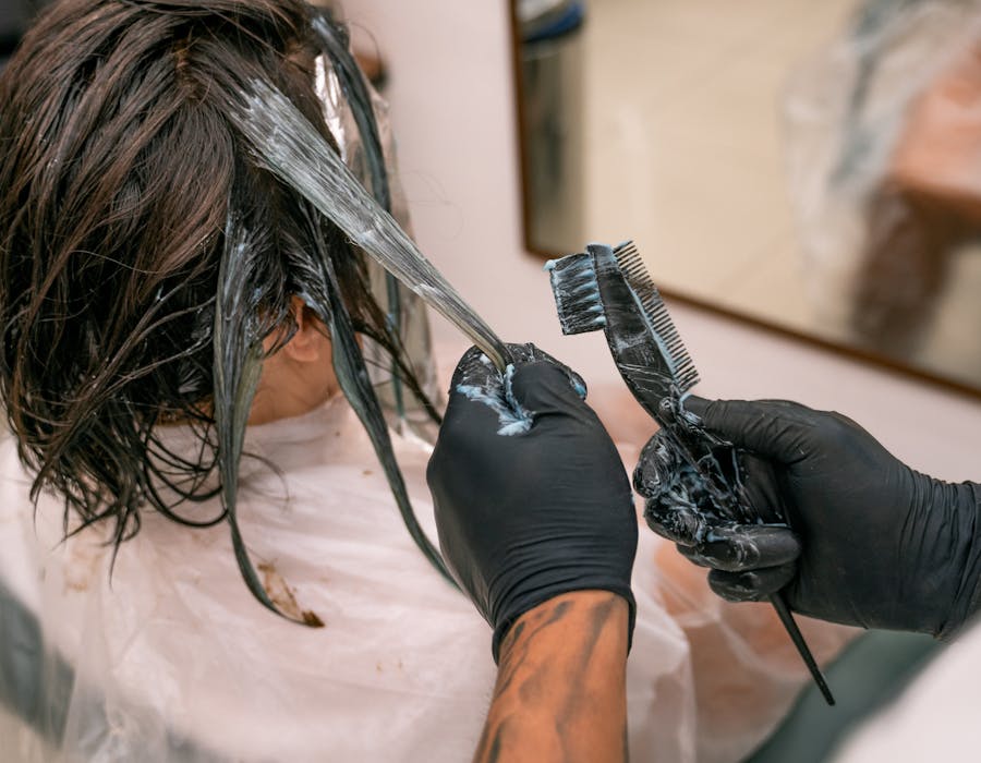 Profissional de cabeleireiro a finalizar penteado em cliente
