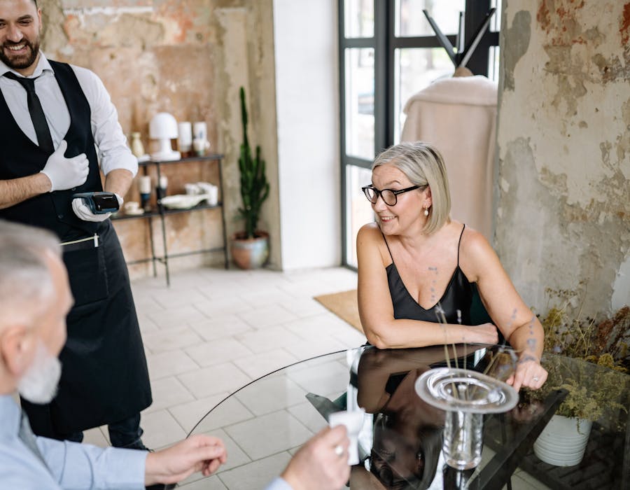 Empregado a apresentar terminal de pagamento num restaurante elegante