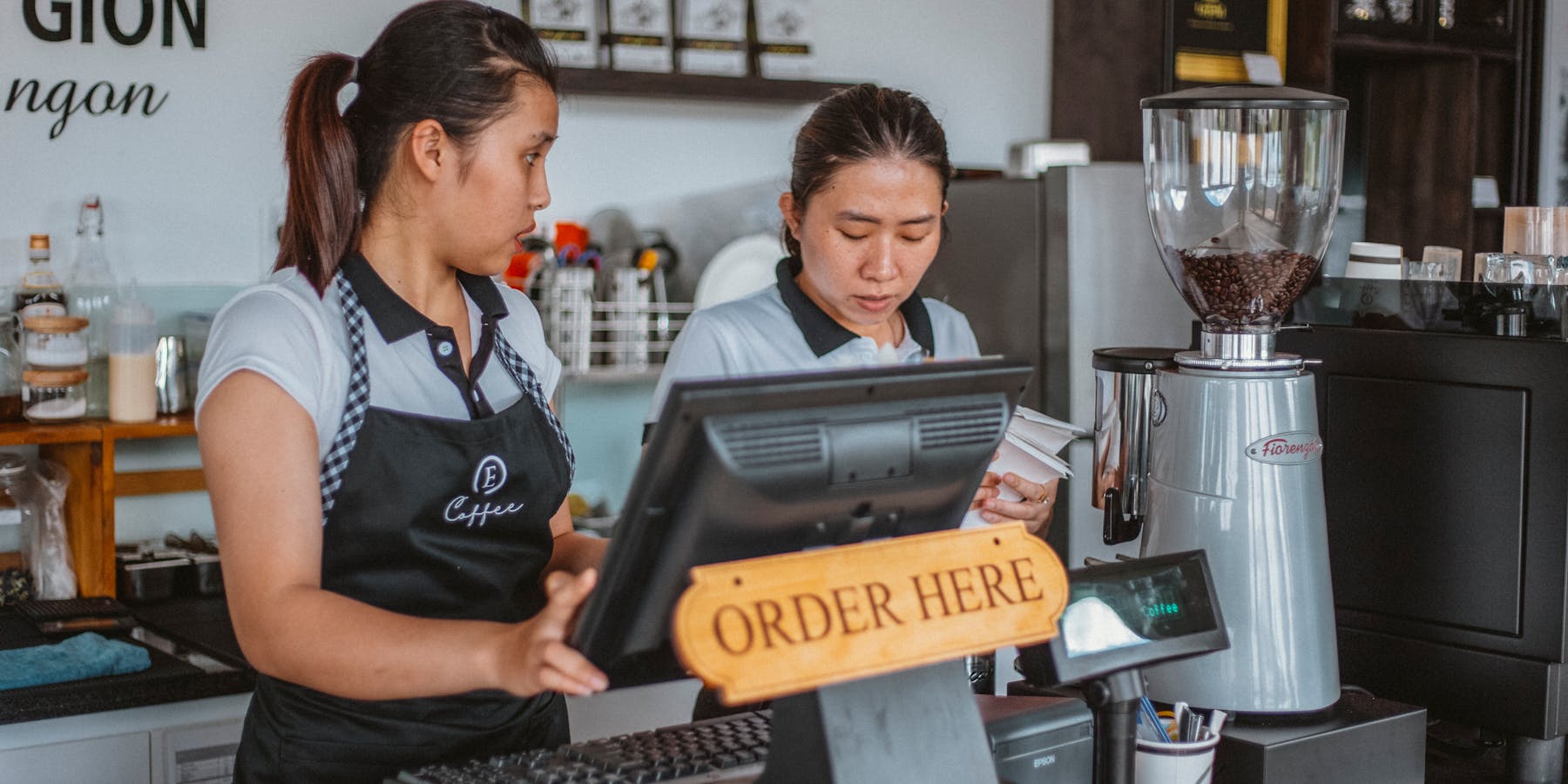 Caixa a operar terminal POS num restaurante rápido